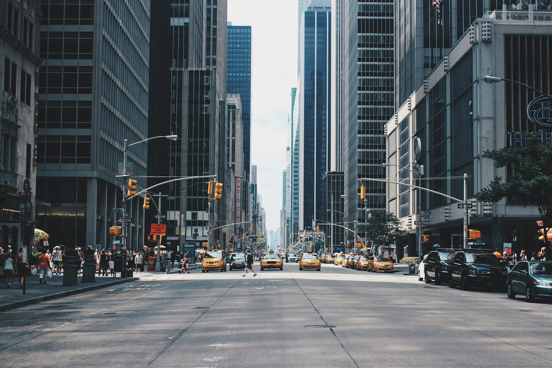 Avenida urbana movimentada entre prédios altos